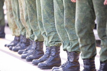 Line up soldiers in protective clothing and boots. They are sent to war or training. - Powered by Adobe