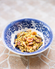 Cooked sardinain seafood pasta fregola with gamberi, cozze e calamari served in an ornate bowl with...