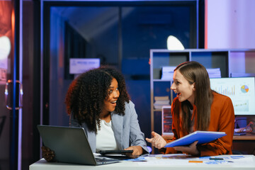 Happy businesspeople while collaborating on a new project in an office. Two businesspeople using a laptop and tablet