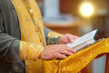 The hands of an Orthodox priest hold a bible