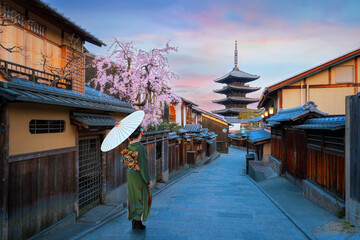 Young Japanese woman in traditional Kimono dress with Yasaka Pagoda in Kyoto, Japan during full...