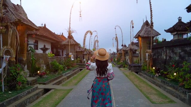 Female tourist in traditional clothing Walk in Penglipuran Village in Bali, an ancient village in Indonesia The cleanest village in the world The traditional buildings are intricate and beautiful