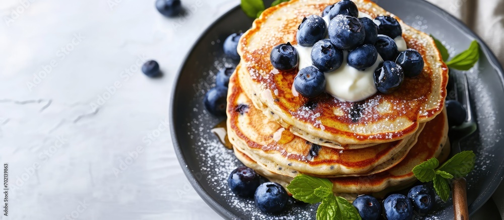 Poster Chia seed pancakes with yogurt and blueberries on plate closeup view. with copy space image. Place for adding text or design