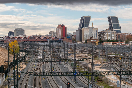 Urban landscape with railway tracks and in the background the city with tall and modern office buildings in a financial area in Madrid in Spain