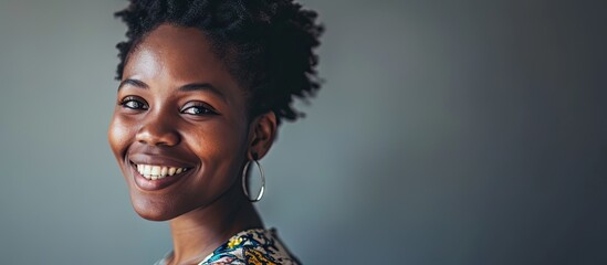 A young black female freelancer looks confidently into the camera and smiles Woman in her 20s student or teacher client or visitor portrait. with copy space image. Place for adding text or design - obrazy, fototapety, plakaty