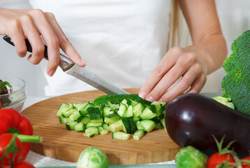 Hands of a woman cutting vegetables