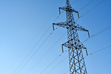 High-voltage power lines against a blue sky background. Towers for the transmission of electricity. Power transmission lines.
