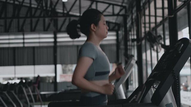 Woman running on treadmill in gym, Cycling at the Gym, Cardio and leg muscle, Building Leg Strength, Exercise for health, Warm up in the gym.