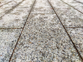 paving stone tiles of square and rectangular shape of gray in perspective. Close up road surface. Abstract Background, texture, frame, place for text, copy space