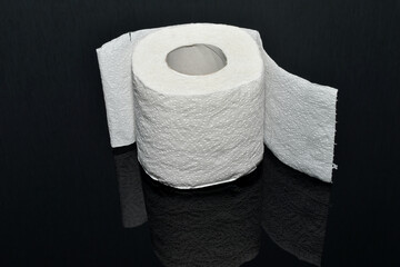 Roll of toilet paper on a dark background.