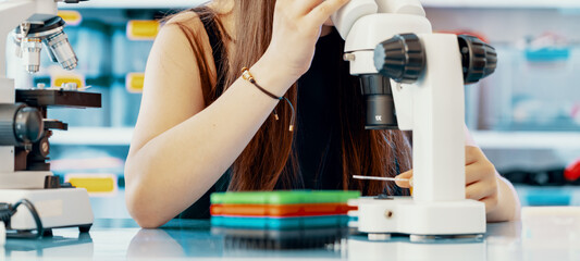Young woman scientist working with microscope in laboratory.