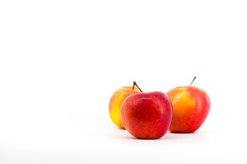 A captivating image featuring vibrant red apples set against a pristine white backdrop. The stark contrast accentuates the apples' freshness, creating a visually appealing and elegant composition.