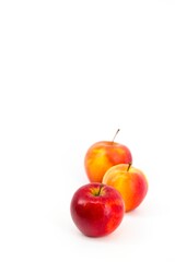 A captivating image featuring vibrant red apples set against a pristine white backdrop. The stark contrast accentuates the apples' freshness, creating a visually appealing and elegant composition.