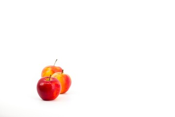 A captivating image featuring vibrant red apples set against a pristine white backdrop. The stark contrast accentuates the apples' freshness, creating a visually appealing and elegant composition.