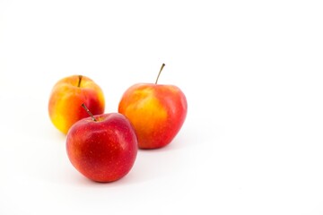 A captivating image featuring vibrant red apples set against a pristine white backdrop. The stark contrast accentuates the apples' freshness, creating a visually appealing and elegant composition.