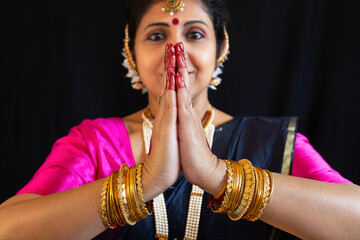 Indian female classical dancer in Bharatanatyam salutation posture isolated on black background