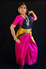 Indian classical dancer performing Bharatanatyam dance mudra with black background