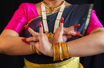 Bharatanatyam mudra demonstrated by female Indian classical dancer with black background