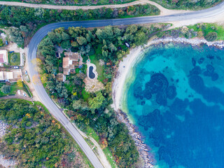 A top view of a winding road that runs along the shore of azure beach