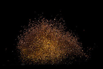 Ground Coffee roasted powder dust fly explosion, Coffee crushed ground float pouring. Roasted Coffee powder ground dust splash explosion in mid Air. Black background Isolated gold bokeh