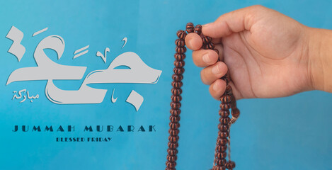 Jummah Mubarak blessed happy Friday Arabic calligraphy, Selective focus image hand of Muslim woman...