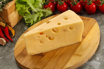 Swiss Maasdam cheese triangle over board