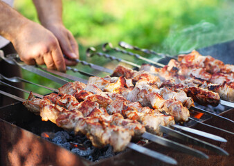 Marinated shashlik, lamb meat grilling on metal skewer, close up