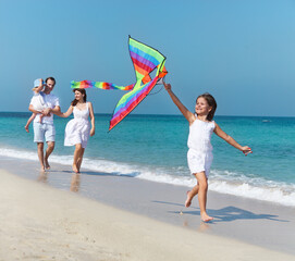 Happy young family with flying a kite