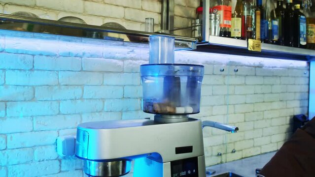 Skillful chef turns on blender filled with hot fried meat and dry ice. Process of grinding chilled meat paste with vegetables