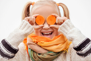 Carrot as Eyes Vitamins for Children. Happy Emotional Little Child Girl Having Fun with Carrot...