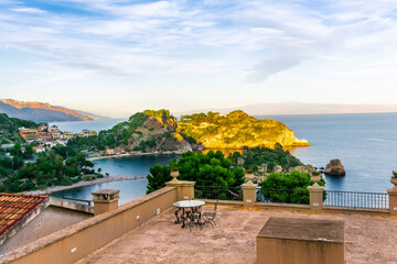 panoramic view from a hotel balcony with terrace to a beautiful sea gulf with sceniv isle and mountains with cloudy sky on background