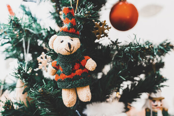 Merry Christmas, Happy New Year background.Bear toy hanging on the Christmas tree, close up.