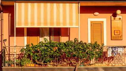 view of medeterranean street with vintage buildings , beautiful windows and picturesque balcony with attributes of traditional italian country life