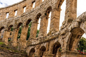 arc wall of ancient building in arena colosseum style, typical roman architecture with arches, windows and vintage yellow facade