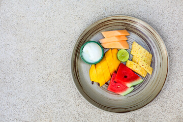 Fruit platter with watermelon, mango, pineapple, lime, melon and icecream