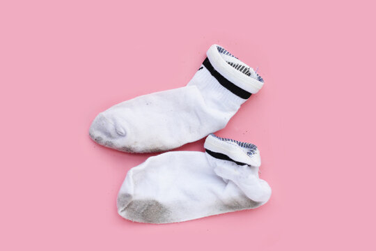 Dirty white socks on pink background.