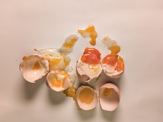pile of broken chicken eggs with a white background