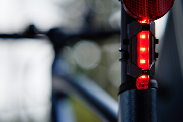 Glowing bicycle taillight. Red stop light for cyclist safety. Rear led light on bike