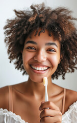 Black girl smiles, shows beautiful well-groomed teeth and holds a toothbrush in his hand