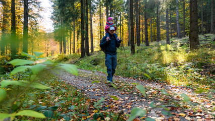 Papa und Tochter beim Wandern im Herbst