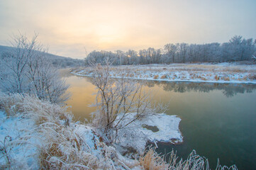 Experience the charm of a frozen river at dawn. Immerse yourself in a whimsical winter wonderland....