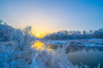 Enjoy the spectacular beauty of the colorful sunset over the icy river. Be enchanted by the warm...