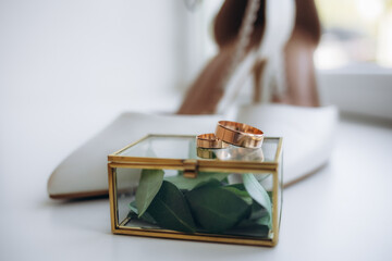 Bride's shoes and wedding ring on a glass table. Wedding traditional bride's accessories