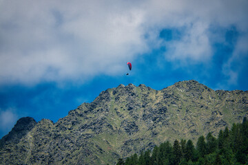 Blick auf ein Felsmassiv über dem ein Paraglider segelt