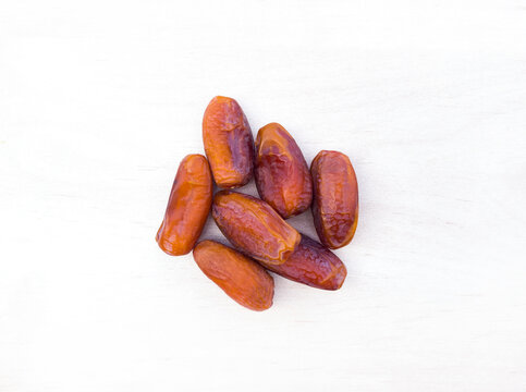 Dates palm tamar.
dried fruits for happy
Tu Bishvat.
Healthy natural food with lots of minerals and vitamins. On a white background wooden texture. from above top View with free space for text
