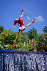 Beautiful Asian girl performing show aerial hoop or aerial ring in various positions and spinning...