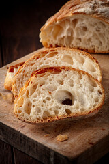 Slices of french baguette on wooden rustic board. Front view.