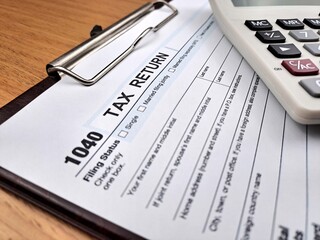 1040 Close up of a Taxes return form with calculator and ballpoint pen.