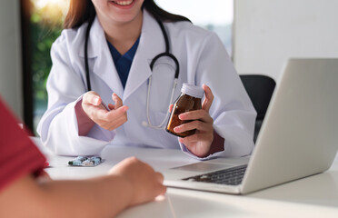 An Asian female doctor is consulting a patient who comes to discuss taking medication for health care. and treat disease with medicine