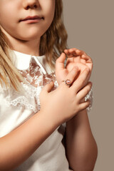 Jewellery concept. Crop image of cover girl child model advertising jewelry showing hand with ring...